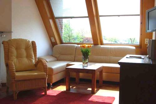 a living room with a couch and a chair and a table at Wohlfühlhotel Hörn van Diek Garni mit Schwimmbad in Bensersiel