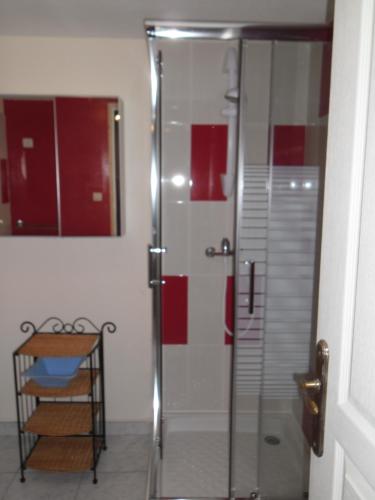 une douche avec une porte vitrée dans une salle de bain dans l'établissement gite colorado, à Renac