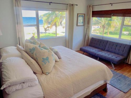 Ebb Tide Resort في بومبانو بيتش: غرفة نوم بسرير كبير وأريكة زرقاء