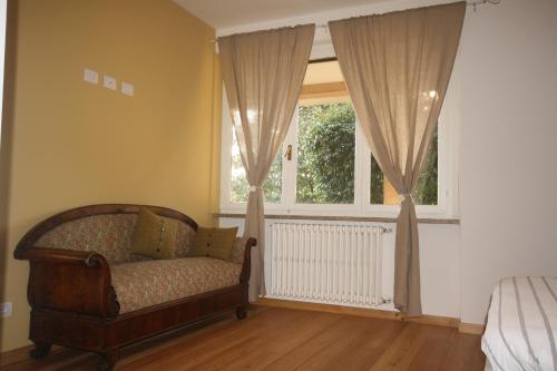 a bedroom with a couch in front of a window at Agriturismo Badalone in Domaso