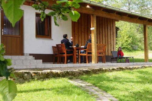 a group of people sitting at a table on the porch of a house at Bio-Erlebnisbauernhof Doll in Nittenau