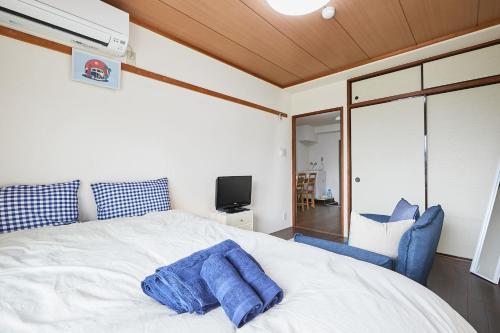 a bedroom with a white bed and a blue chair at Sun white Gyoutoku 202 in Urayasu