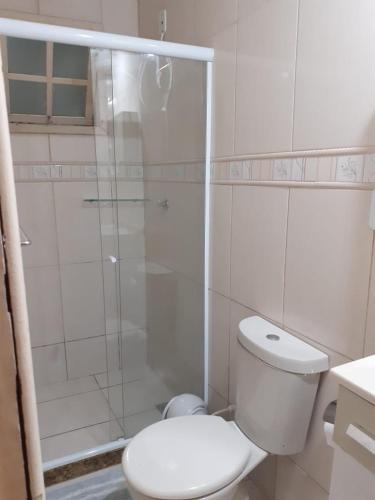 a white bathroom with a toilet and a shower at Menina da Lua in Rio das Ostras