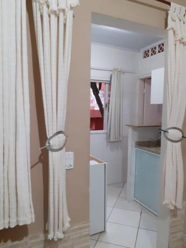 a kitchen with a door with curtains in it at Menina da Lua in Rio das Ostras