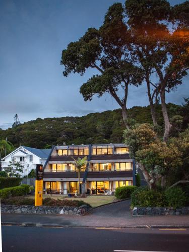 an exterior view of a building with trees at Pioneer Waterfront Apartments in Paihia