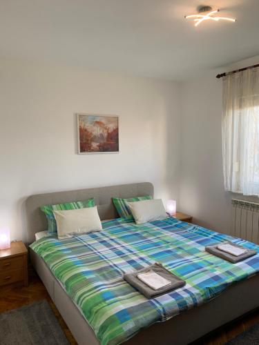 ein Schlafzimmer mit einem großen Bett mit einer bunten Decke in der Unterkunft Apartman MADAPE in Sesvete