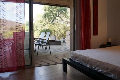 a bedroom with a bed and a sliding glass door at Résidence Cala Sultana in Porto-Vecchio