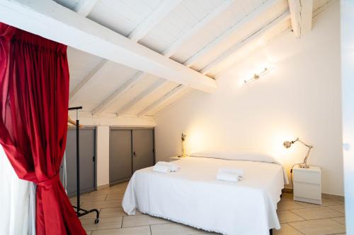 sypialnia z białym łóżkiem i czerwoną zasłoną w obiekcie V12 Apartments - Vittoria 12 w mieście Novara