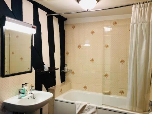 a bathroom with a shower, sink, and toilet at Brook Red Lion Hotel in Colchester