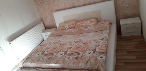 a small bedroom with a bed with pink roses at Apartments Holiday in Vranje