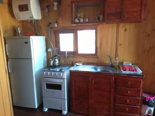 eine Küche mit einem Kühlschrank, einem Herd und einer Spüle in der Unterkunft Cabañas El Caribe - Martinica in San Luis