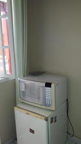 a microwave sitting on top of two refrigerators at Menina da Lua in Rio das Ostras