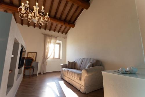 a living room with a couch and a chandelier at Fattoria L'Olmetto in Pisa