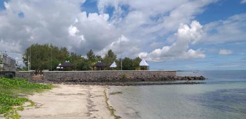a beach with some buildings and the water at Villa Cococherie in Poste Lafayette