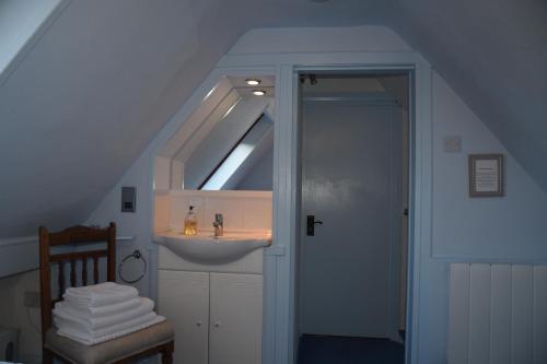 a bathroom with a sink and a staircase with a skylight at Chapelhill Croft in Keith