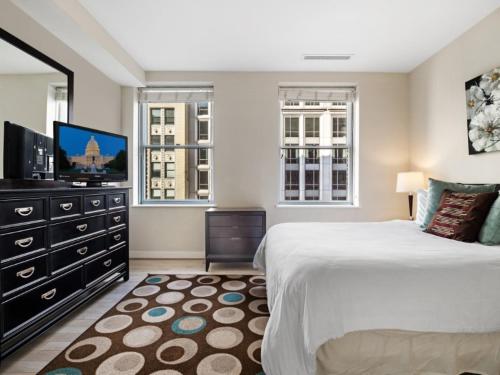 فندق غلوبال لاكجري سويتس آت ذا وايت هاوس في واشنطن: غرفة نوم بسرير كبير وتلفزيون بشاشة مسطحة