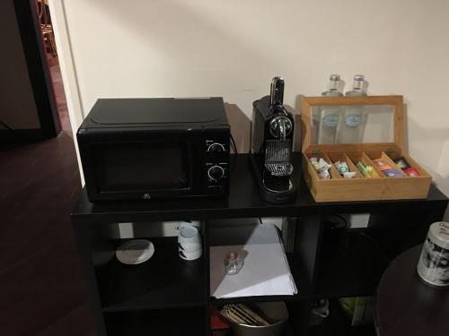 a microwave oven sitting on top of a table at Au Père Tranquille in Tinchebray