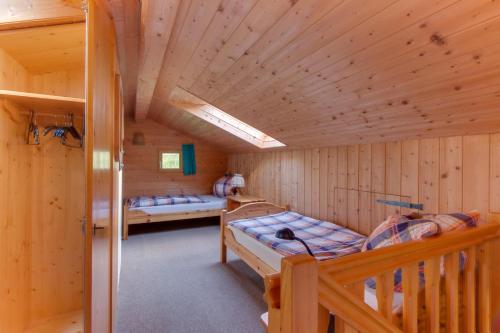 Habitación con 2 camas en una cabaña de madera en Ferienwohnung Schmidt - Natur und Ruhe, en Schwaigen