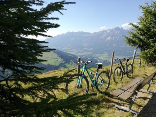 two bikes parked next to a bench on a mountain at Appartements Oberhauser in Westendorf