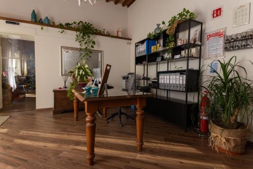 an office with a wooden desk and shelves with plants at Fattoria L'Olmetto in Pisa