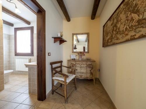 ein Badezimmer mit einem Stuhl, einem Waschbecken und einem Spiegel in der Unterkunft Agriturismo Forzello in Ariano nel Polesine