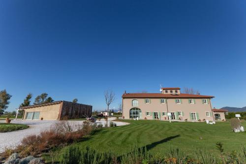 a large white house with a green lawn at Fattoria L'Olmetto in Pisa