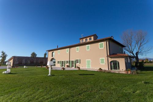 a large building with a grass field in front of it at Fattoria L'Olmetto in Pisa