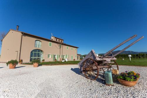 an old fashioned wagon sitting in front of a house at Fattoria L'Olmetto in Pisa