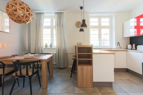 een keuken en eetkamer met een tafel en stoelen bij Republika Kopernika Apartment in Toruń