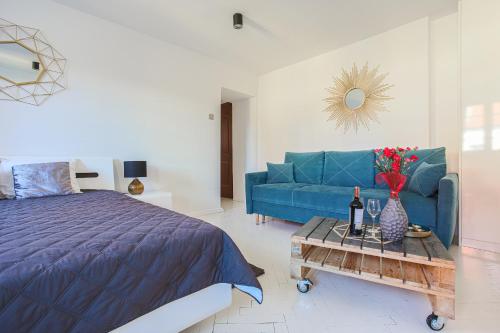 een slaapkamer met een blauwe bank en een tafel met bloemen bij Republika Kopernika Apartment in Toruń