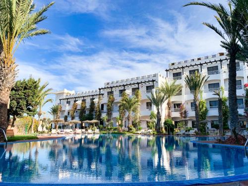 a hotel with a swimming pool in front of a building at Borjs Hotel Suites & Spa in Agadir