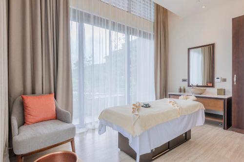 a hotel room with a bed and a chair at Gran Melia Arusha in Arusha
