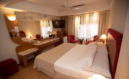 a hotel room with a large bed and a desk at Hotel Garden in Rosario