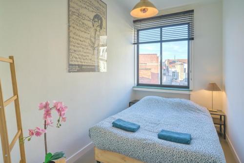 um quarto com uma cama e uma janela em Apartment with Rooftop Terrace in the Heart of Antwerp em Antuérpia