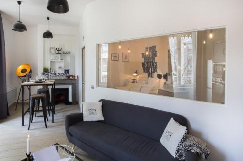 een woonkamer met een blauwe bank en een tafel bij Suite Garibaldi Cosy et Design in Lyon