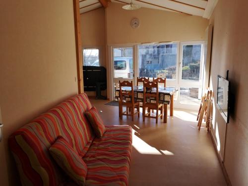 a living room with a couch and a table and chairs at Les Gîtes du Val in Valprivas