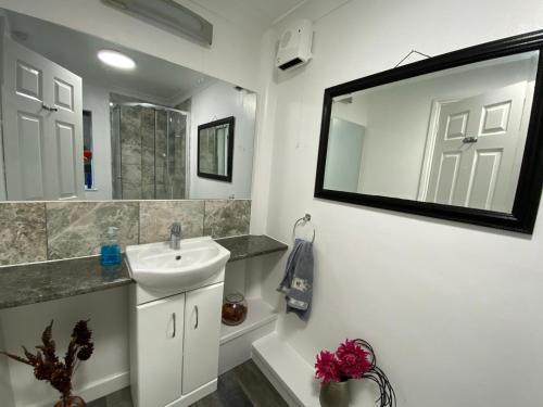a bathroom with a sink and a mirror at Lovely Homes in Aylesbury