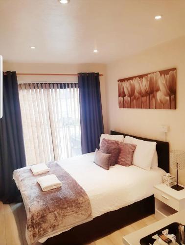 a bedroom with a large bed and a window at The 55 in Enfield