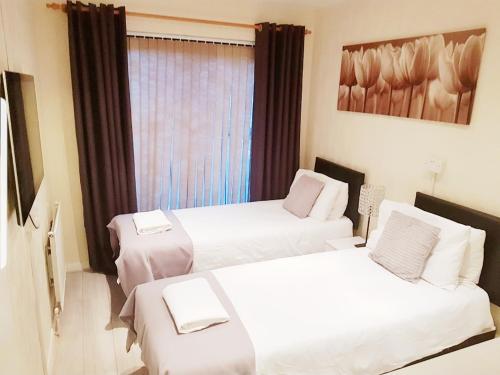a hotel room with two beds and a window at The 55 in Enfield