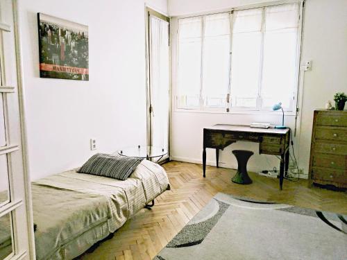 une chambre avec un lit, un bureau et une fenêtre dans l'établissement Le Palladium quartier Tzaréwitch Nice, à Nice