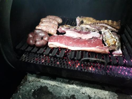 a grill with meat and other foods on it at Casona Los Arri in Ushuaia