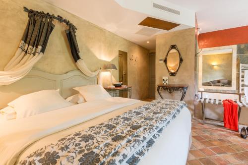 ein Schlafzimmer mit einem großen Bett in einem Zimmer in der Unterkunft Hôtel-Spa Le Saint Cirq in Tour-de-Faure