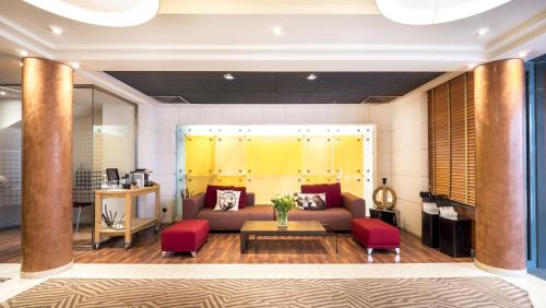 a living room with a couch and red chairs at Hôtel Le Pré Carré in Annecy