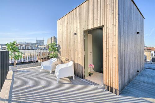a wooden building with two white chairs on a balcony at The Meir Lodge. Apartments in heart of Antwerp in Antwerp