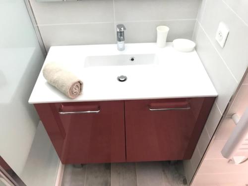 La salle de bains est pourvue d'un lavabo blanc et d'une armoire rouge. dans l'établissement Appartement 2 pieces, renove, 2 piscines+tennis, mer, climatisation, à Antibes
