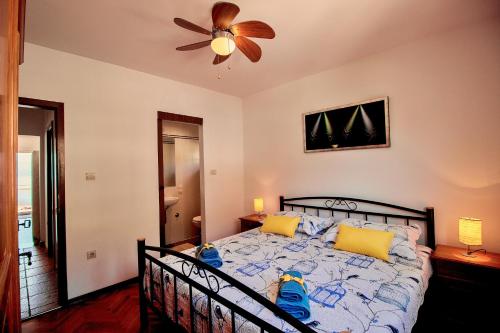 a bedroom with a bed with yellow and blue pillows at Sandy Beach Apartments in Duće