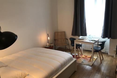 リヨンにあるLe Joyau de Jouhaux appartement G - Lyon Garibaldiのベッドルーム1室(ベッド1台、テーブル、椅子付)