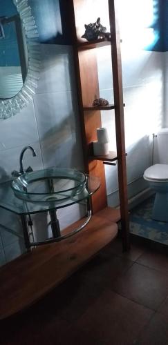a bathroom with a glass sink and a toilet at Les Gîtes de la Lézarde in Petit-Bourg