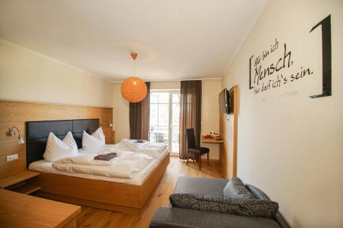 ein Hotelzimmer mit einem Bett und einem Stuhl in der Unterkunft Breitenberger Hof "inklusive Frühstück" in Breitenberg