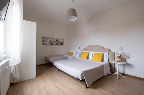 een slaapkamer met 2 bedden en gele kussens bij Cute & Cozy rooms train station in Bergamo
